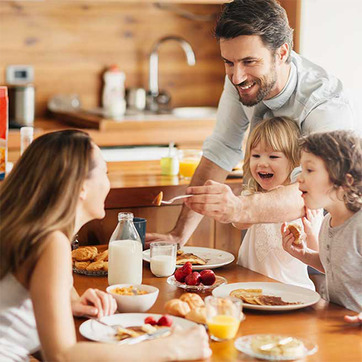 Fröhliche Familie am Frühstückstisch