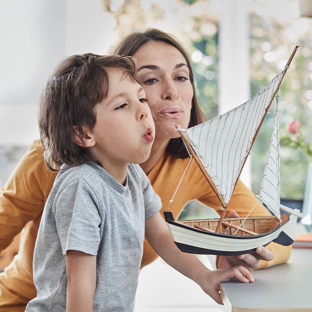 Mutter und Sohn mit Spielzeugschiff