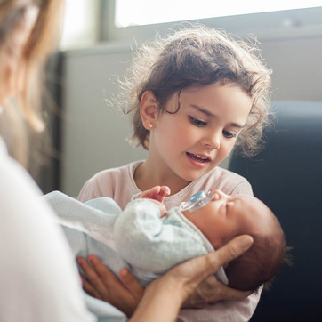 Mädchen hält Baby